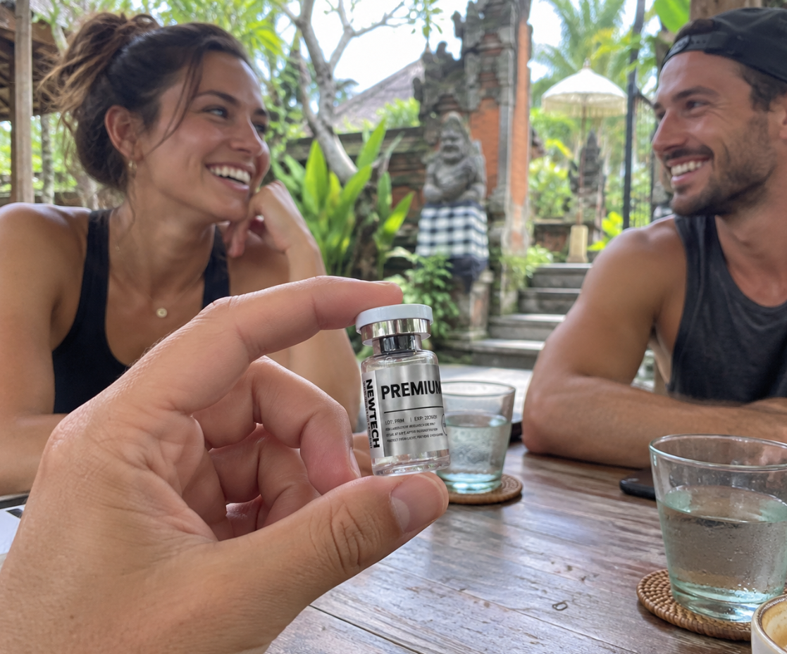 Friends in a Bali cafรฉ with a Newtech vial in the foreground